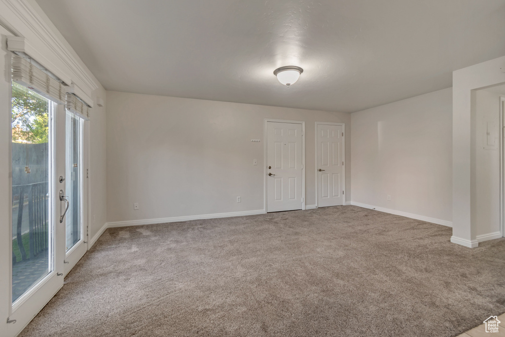 Carpeted spare room featuring baseboards
