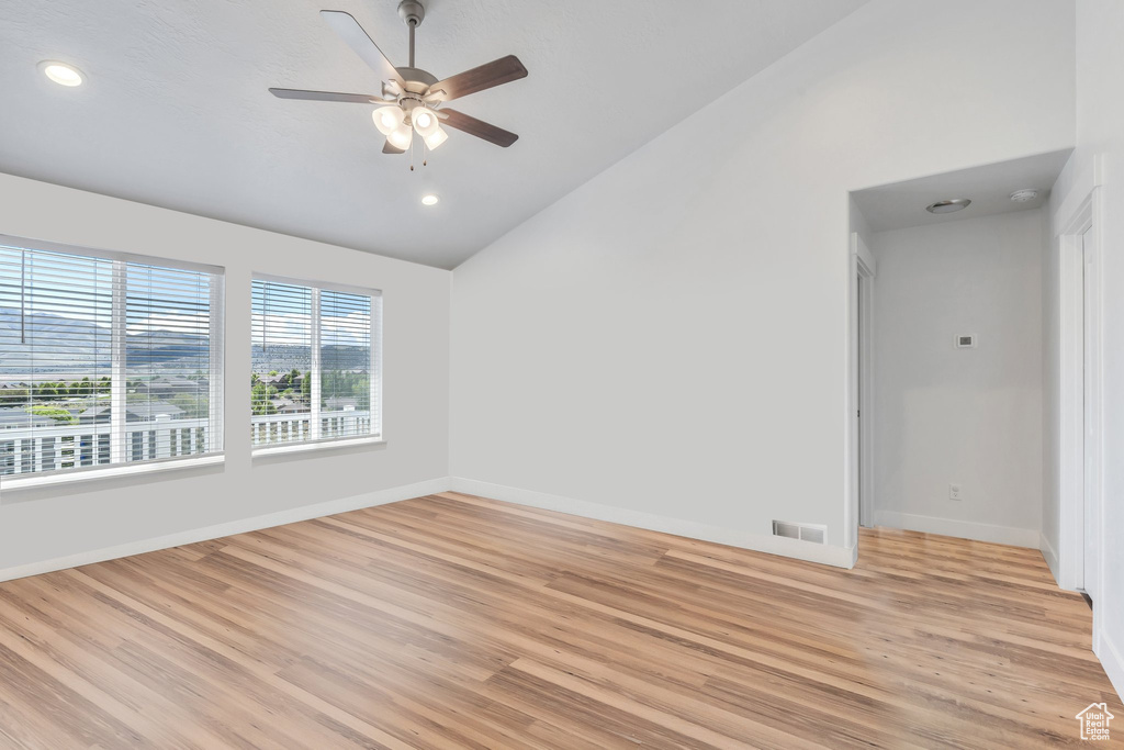 Unfurnished room featuring lofted ceiling, light wood finished floors, baseboards, recessed lighting, and a ceiling fan