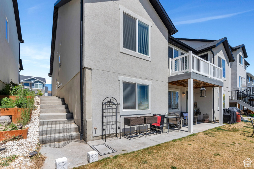 Back of property with stairs, stucco siding, a patio, and a balcony