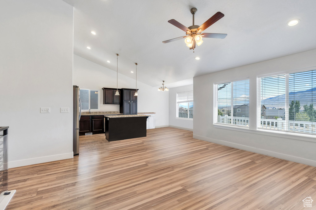 Unfurnished living room with light wood-style flooring, baseboards, recessed lighting, ceiling fan, and vaulted ceiling