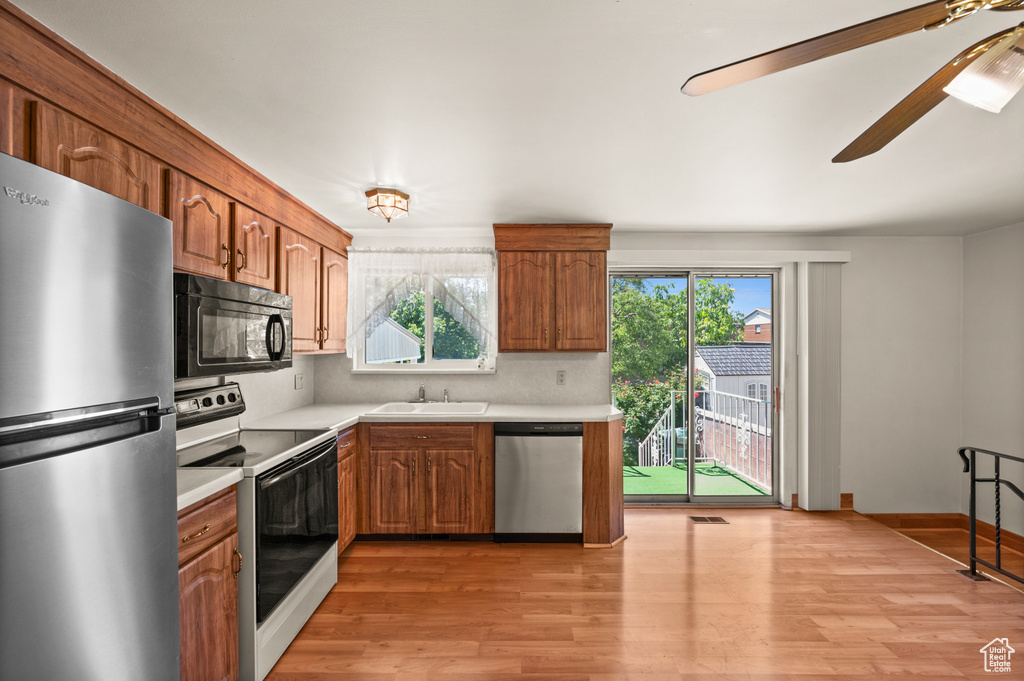 Kitchen featuring appliances with stainless steel finishes, light countertops, healthy amount of natural light, and light wood finished floors
