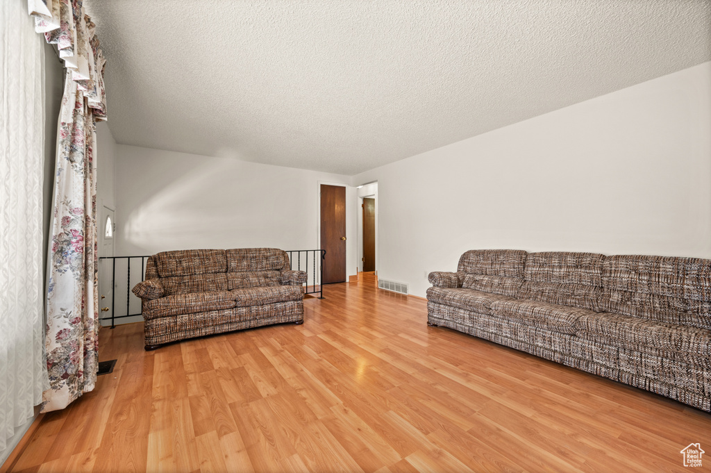 Living area with wood finished floors and a textured ceiling