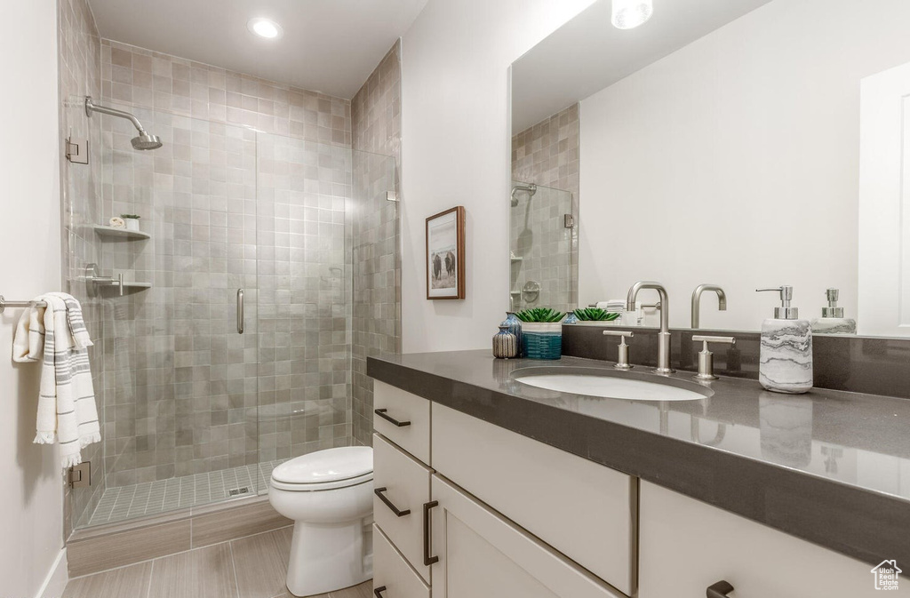 Full bath featuring vanity, toilet, a stall shower, and recessed lighting