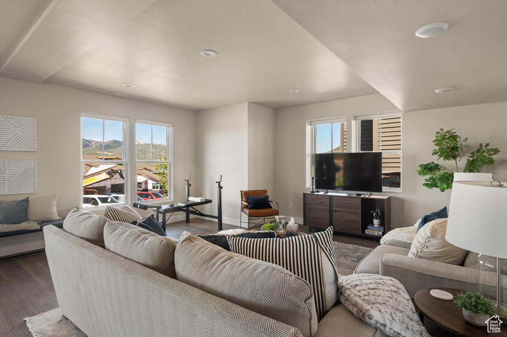 Living area with healthy amount of natural light, wood finished floors, recessed lighting, and baseboards