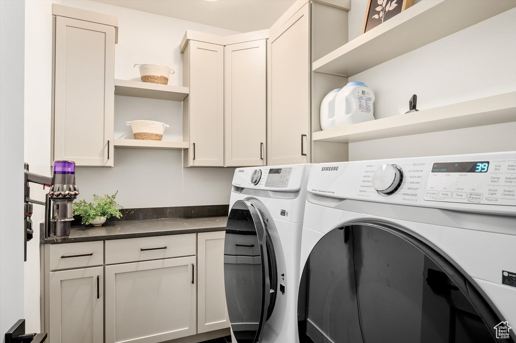 Washroom featuring separate washer and dryer and cabinet space