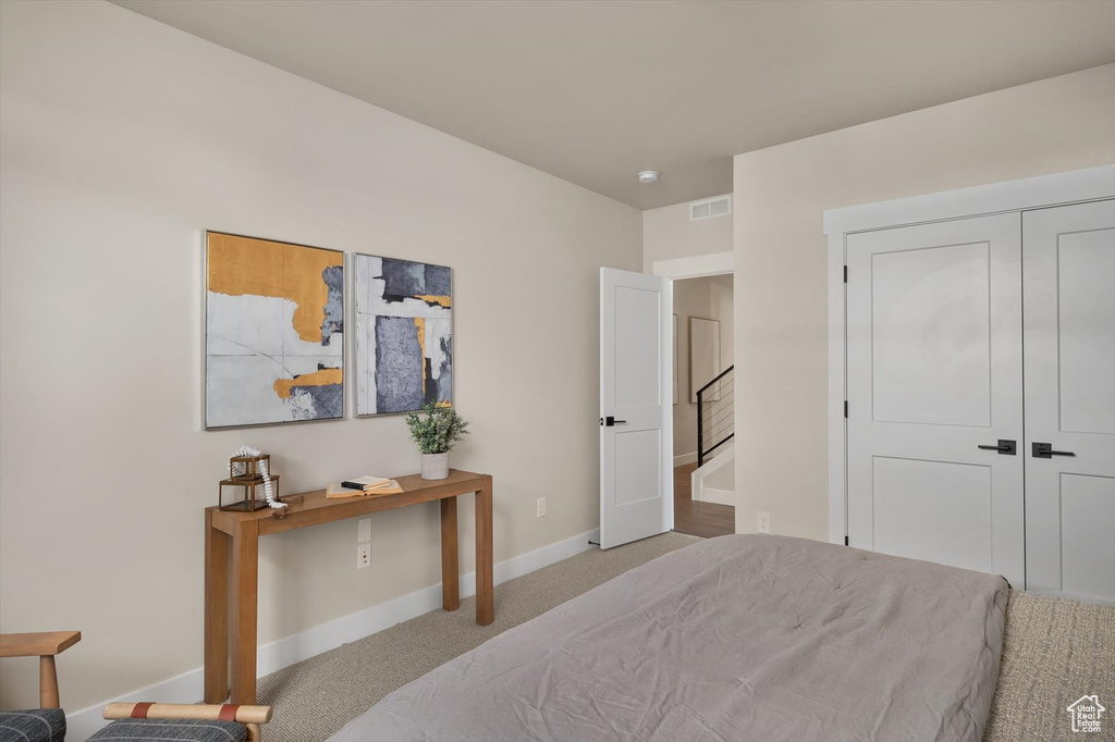 Carpeted bedroom featuring baseboards and a closet