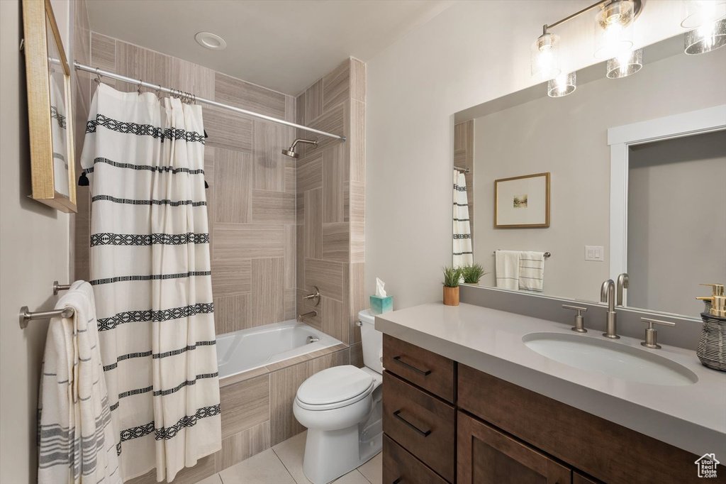 Bathroom with toilet, tile patterned floors, shower / bath combination with curtain, and vanity