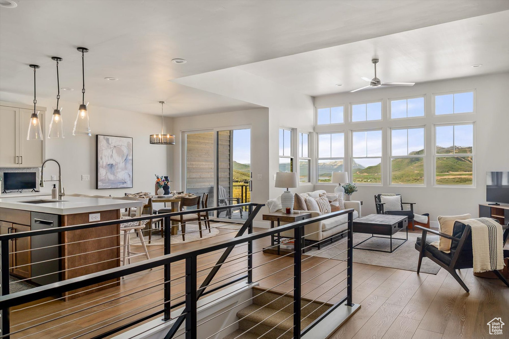 Living room featuring plenty of natural light, wood finished floors, a ceiling fan, and recessed lighting