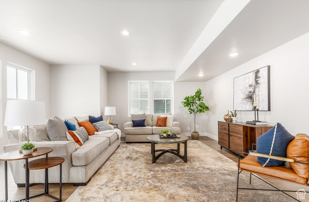 Living room with recessed lighting, wood finished floors, and baseboards