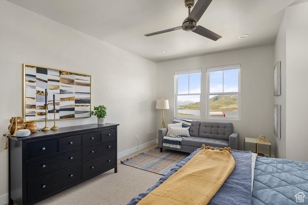 Bedroom with light carpet, baseboards, and ceiling fan