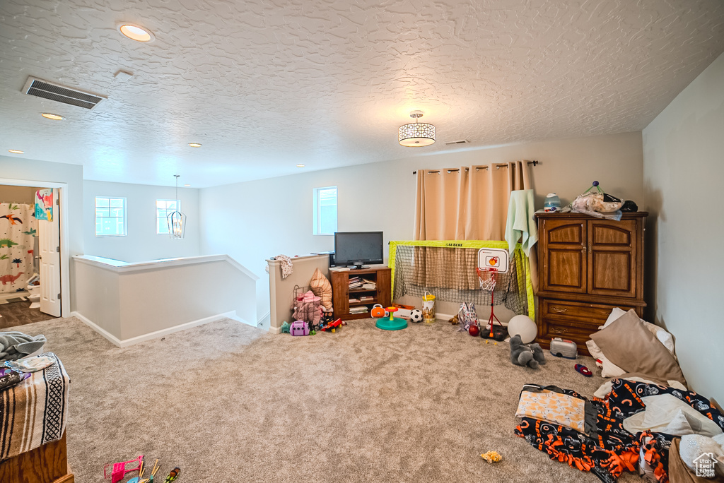 Playroom with carpet floors, baseboards, recessed lighting, and a textured ceiling
