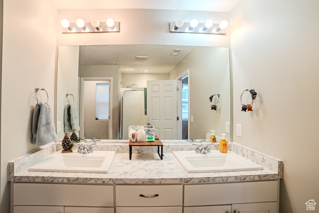 Bathroom featuring double vanity and a stall shower