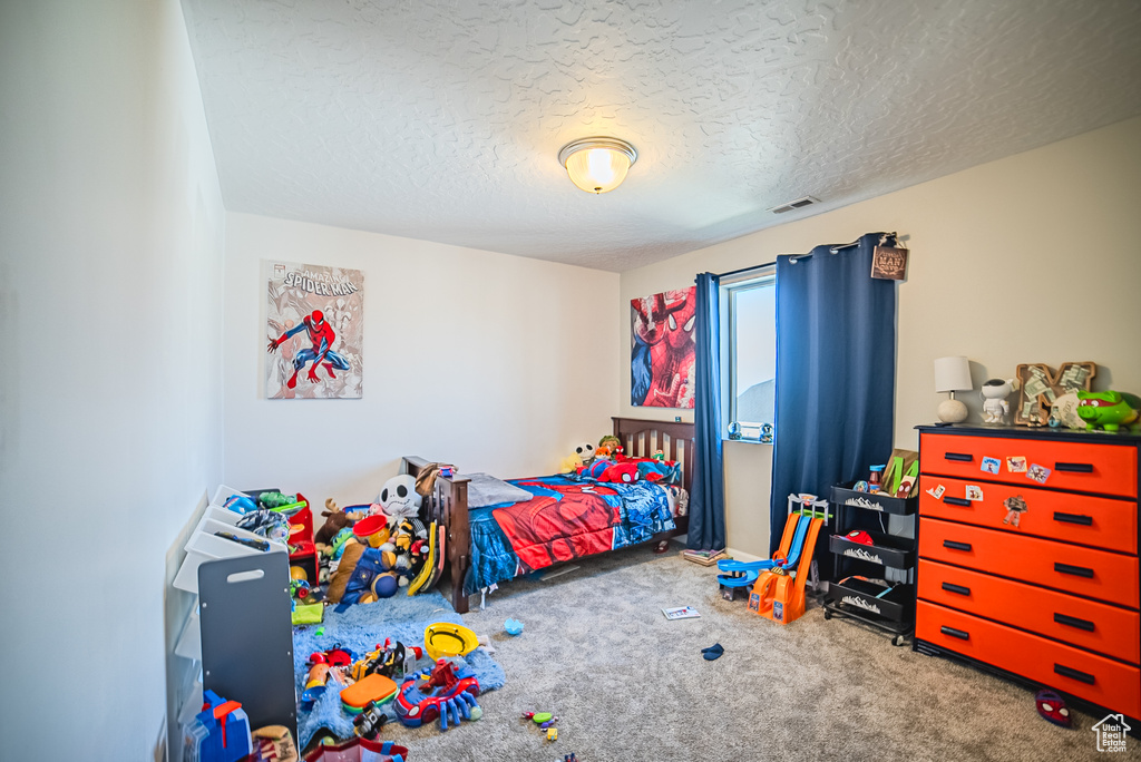Carpeted bedroom with a textured ceiling