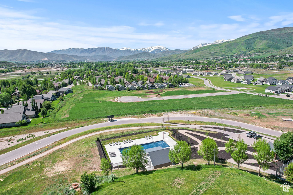 Aerial view of residential area featuring mountains and a pool area