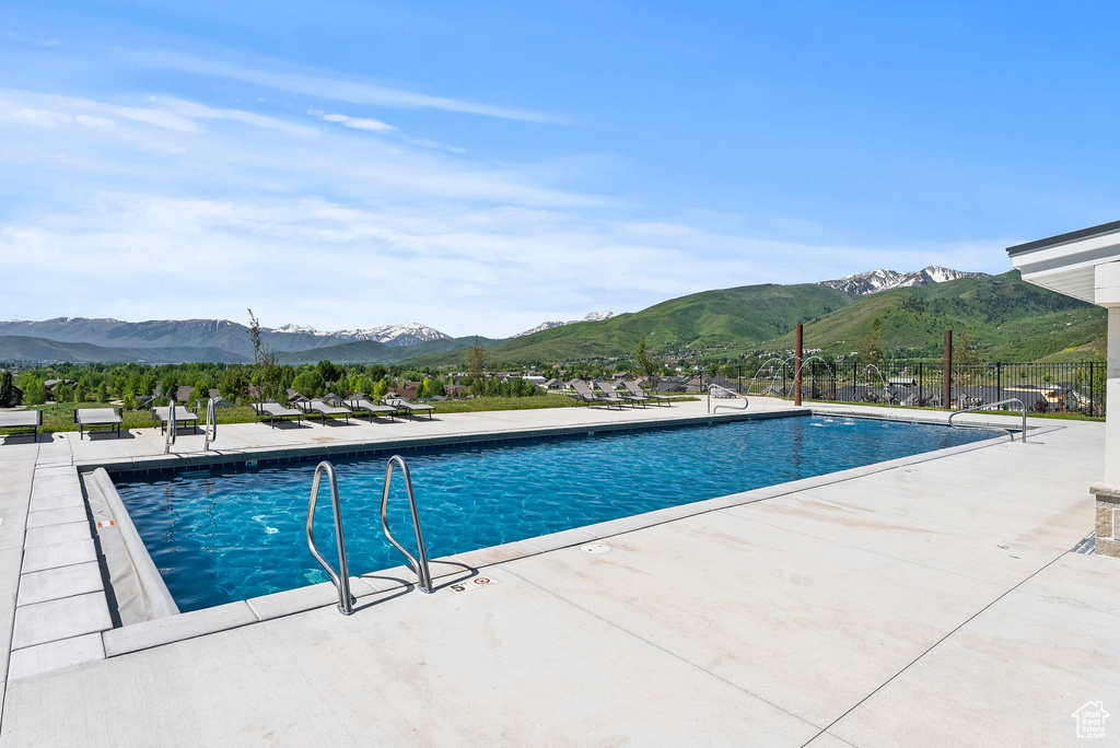 Community pool with a patio area and a mountain view