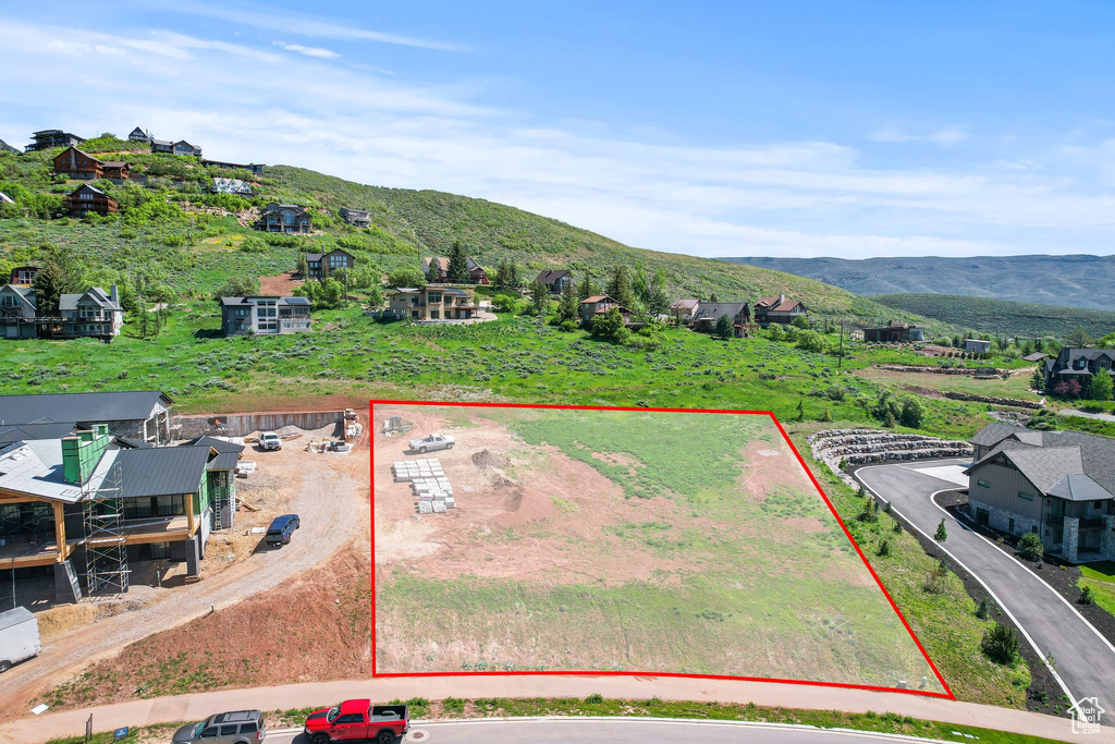 Aerial view of property's location with a mountainous background and property parcel outlined