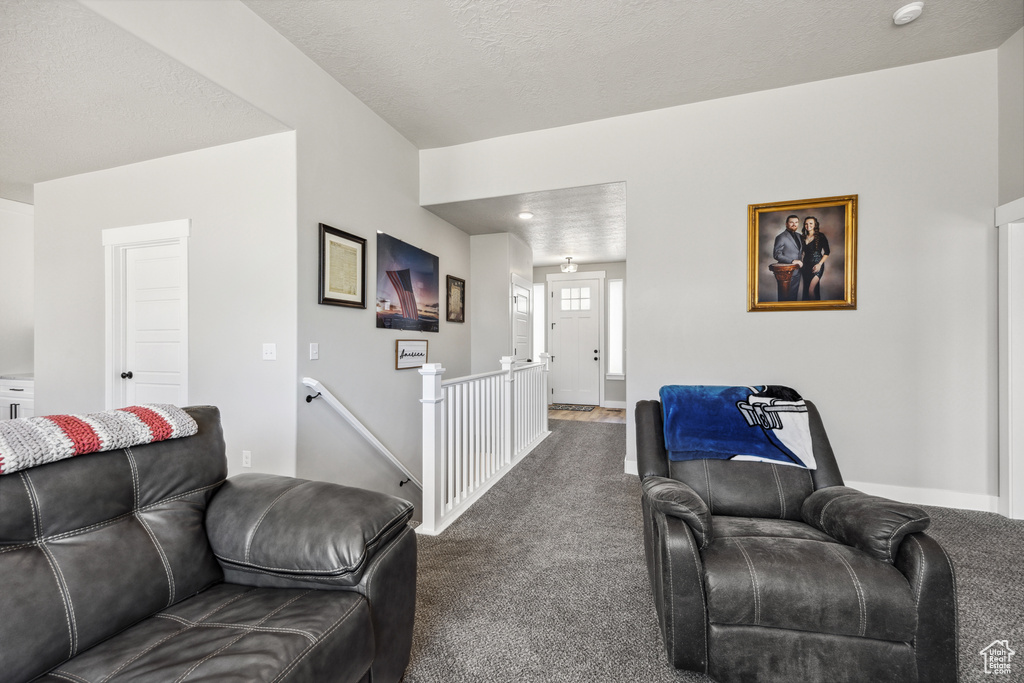 Living room featuring dark carpet and baseboards