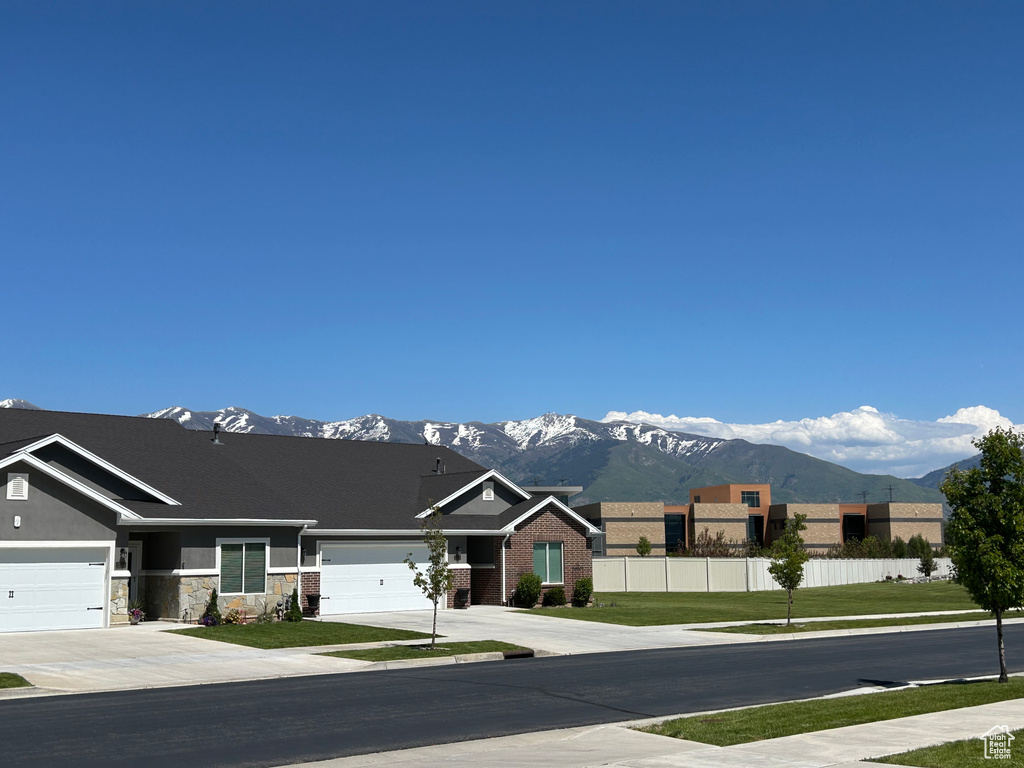 View of asphalt street featuring a mountain view and sidewalks