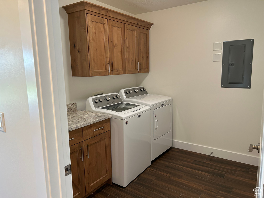 Washroom featuring electric panel, independent washer and dryer, cabinet space, and dark wood-style flooring