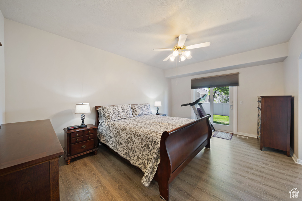 Bedroom featuring access to outside, wood finished floors, a ceiling fan, and baseboards