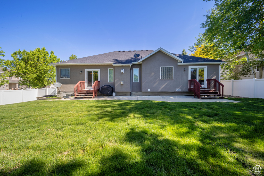 Rear view of property with stucco siding and a patio area