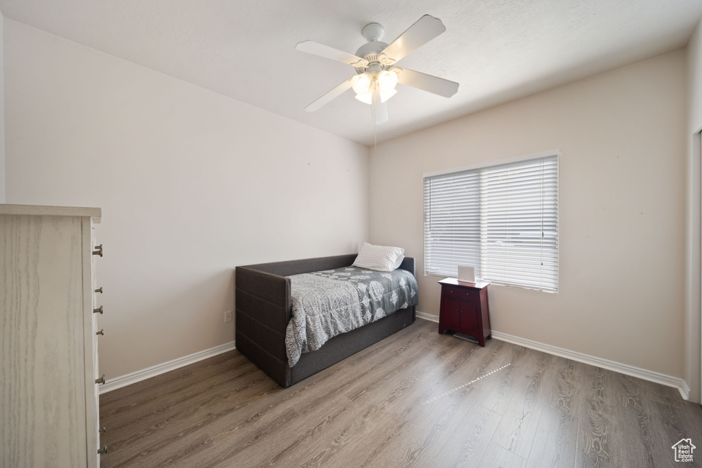 Bedroom with wood finished floors, baseboards, and a ceiling fan
