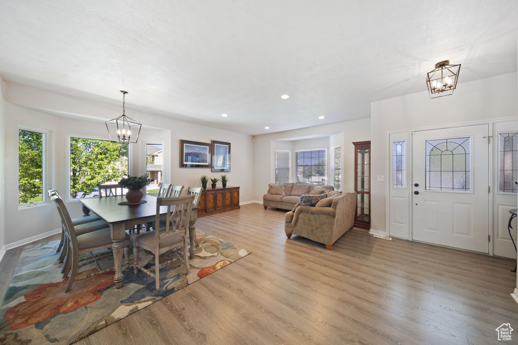 Dining room with a chandelier, wood finished floors, plenty of natural light, and recessed lighting
