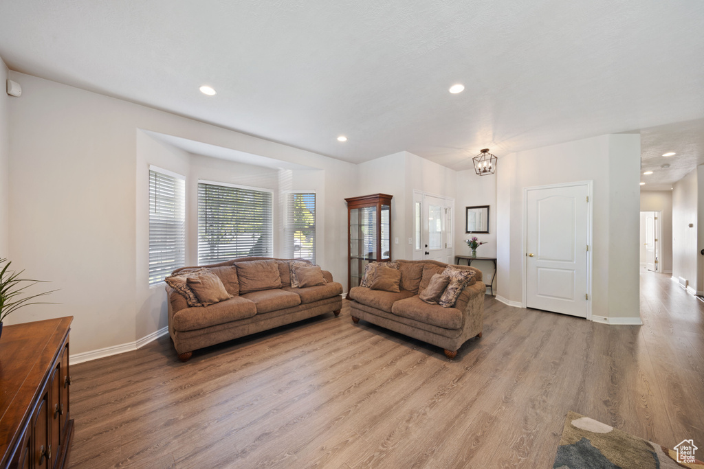 Living area with light wood-style flooring, recessed lighting, a chandelier, and baseboards
