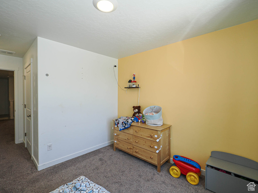 Bedroom featuring carpet and baseboards