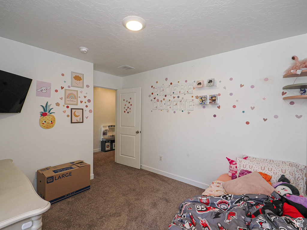 Bedroom featuring carpet and baseboards
