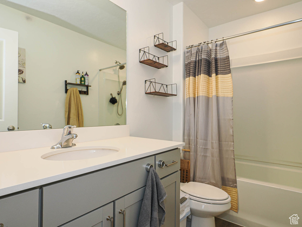 Full bath featuring vanity, shower / bath combo, and toilet