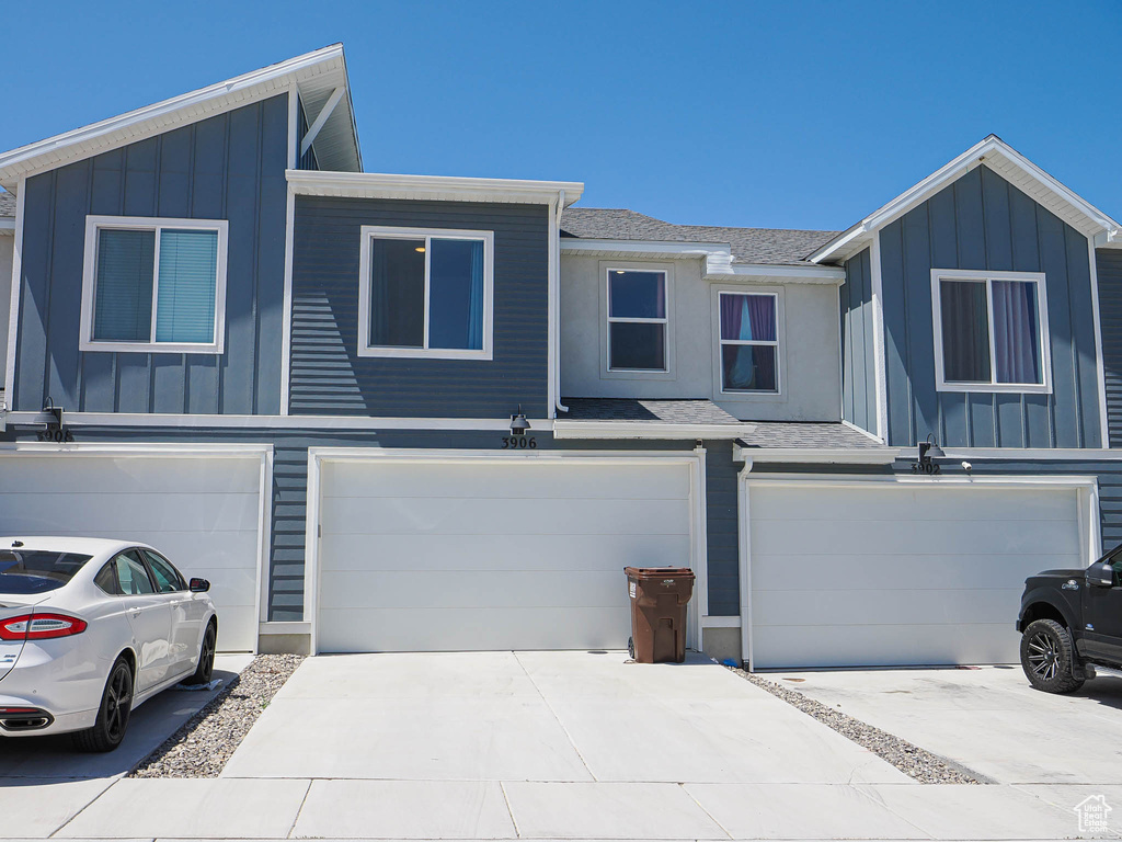 View of front of home featuring board and batten siding, an attached garage, and driveway