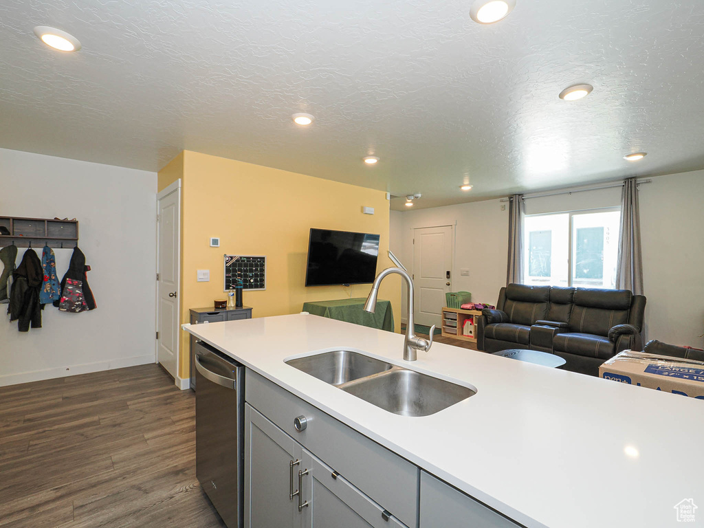 Kitchen featuring a sink, stainless steel dishwasher, open floor plan, gray cabinetry, and recessed lighting