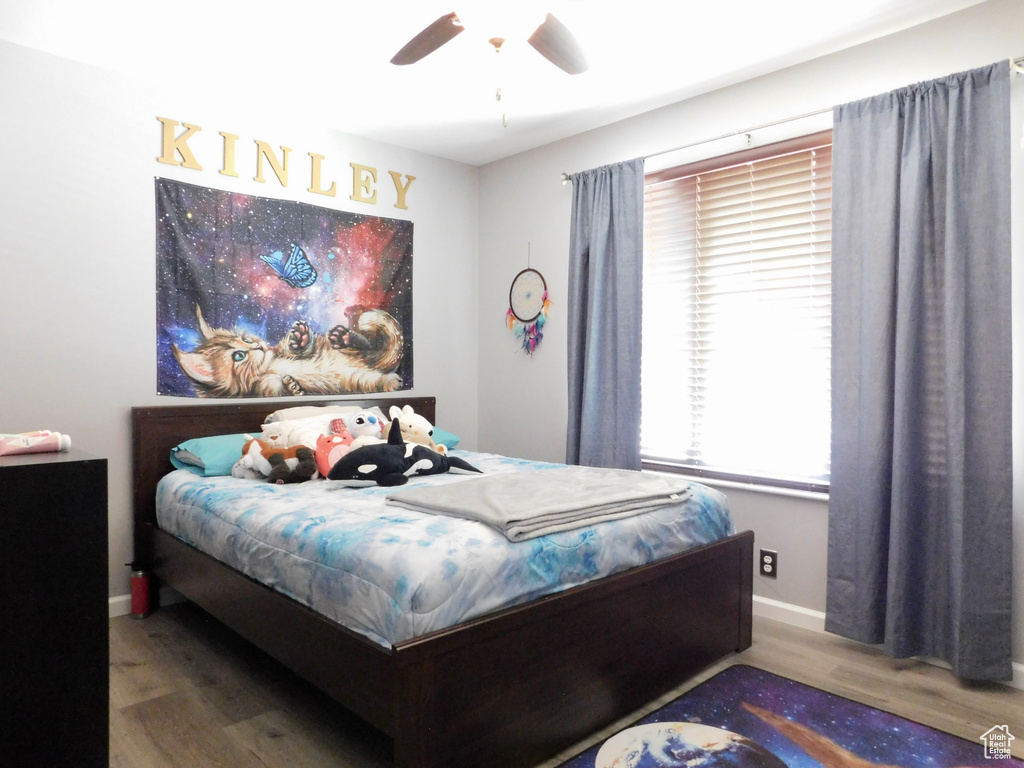 Bedroom featuring wood finished floors, baseboards, and a ceiling fan