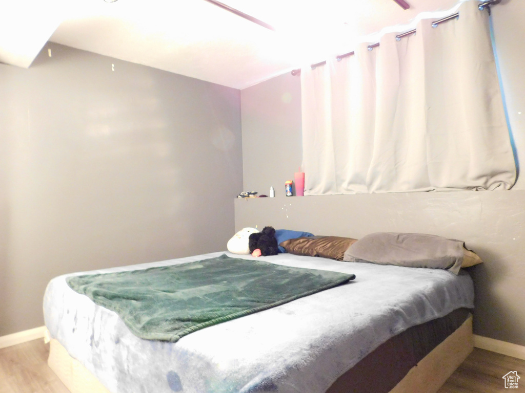Bedroom with wood finished floors and baseboards