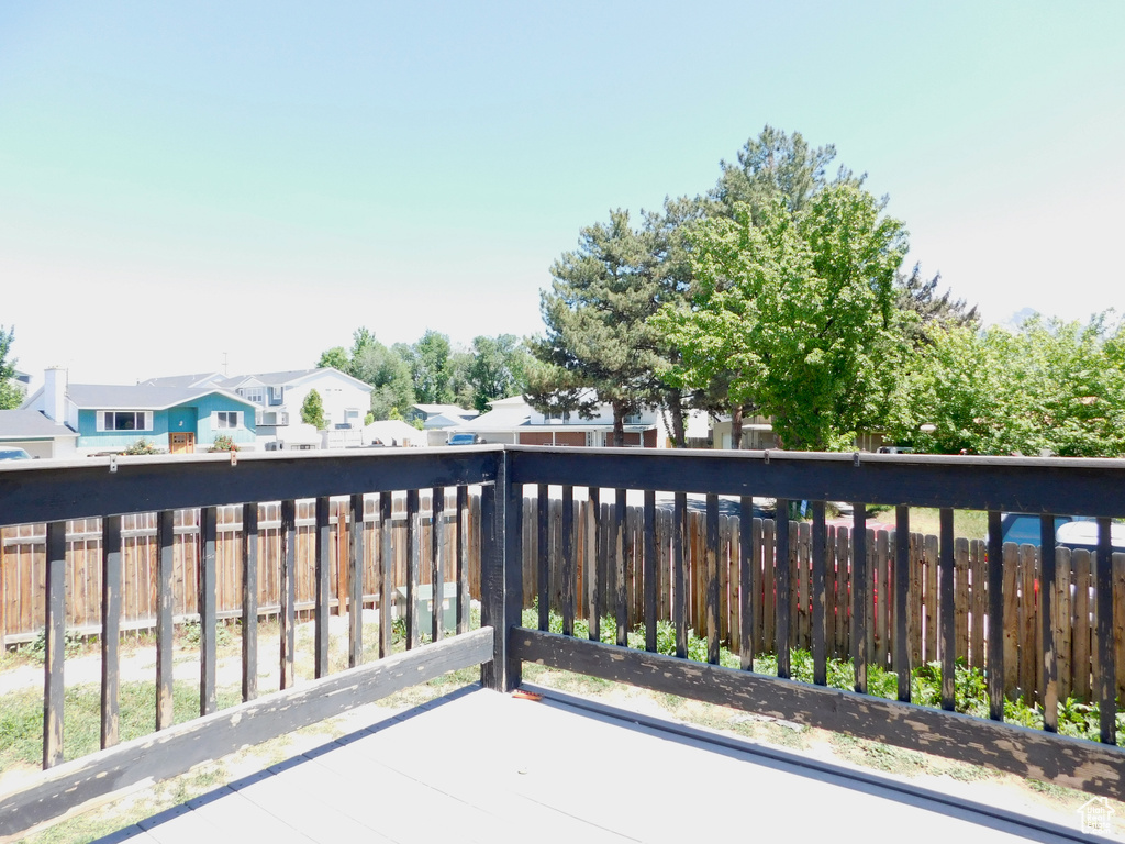 Wooden terrace featuring a fenced backyard and a residential view
