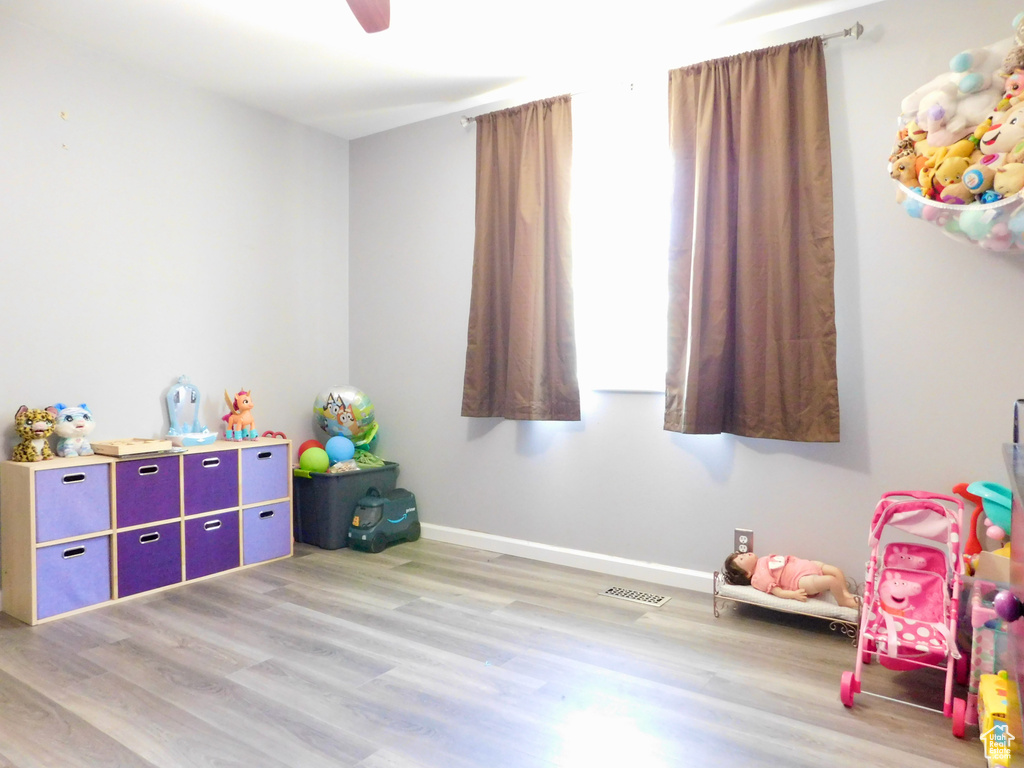Rec room featuring light wood-type flooring, baseboards, and a ceiling fan