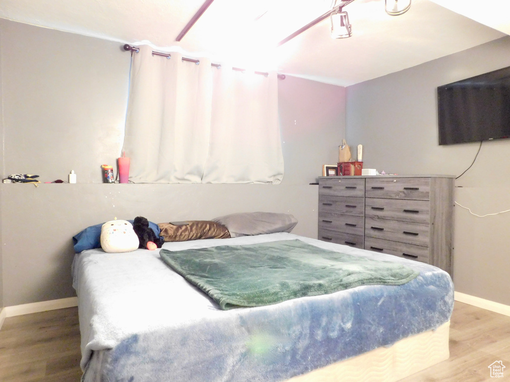 Bedroom with wood finished floors and baseboards