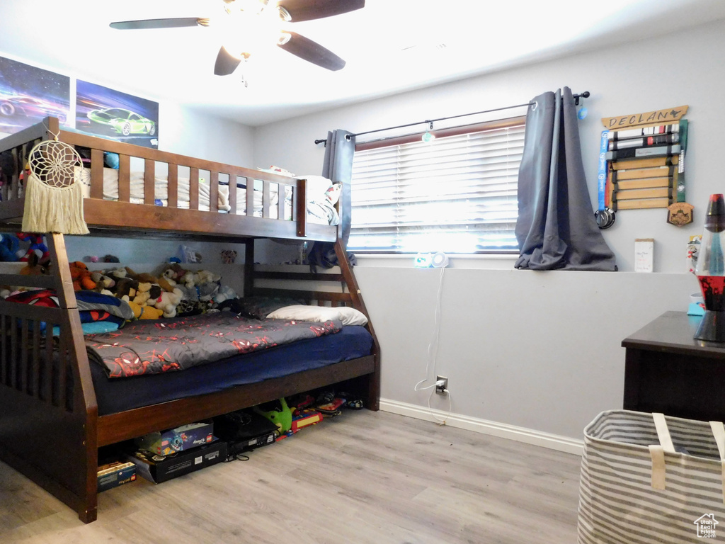 Bedroom featuring wood finished floors, a ceiling fan, and baseboards