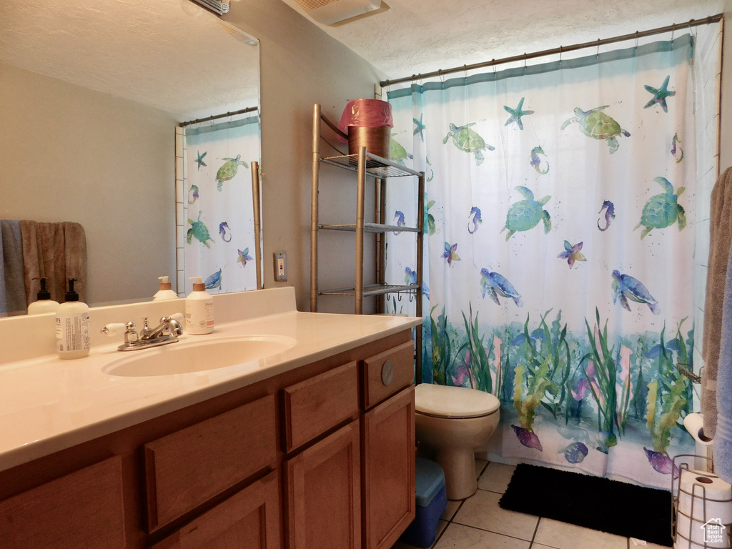 Full bath with vanity, toilet, tile patterned flooring, a textured ceiling, and a shower with curtain