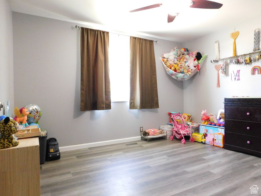 Playroom featuring wood finished floors, ceiling fan, and baseboards