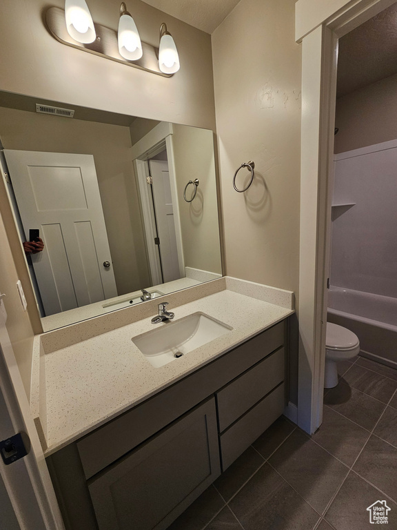 Bathroom with tile patterned floors, vanity, and toilet