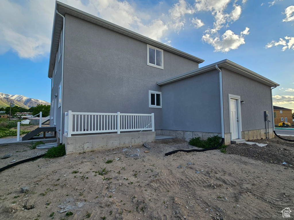 Rear view of house with stucco siding and a mountain view