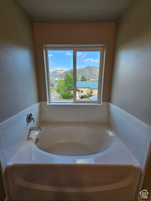 Bathroom with a garden tub and a mountain view