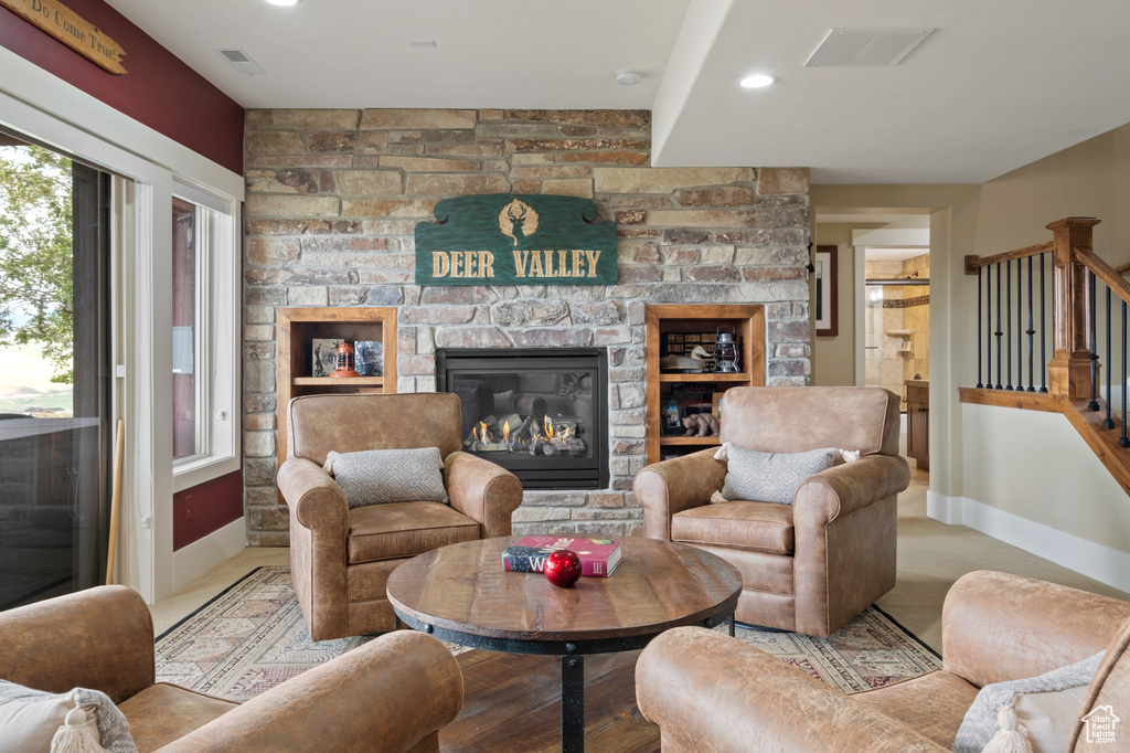 Living area featuring stairway, baseboards, a stone fireplace, and recessed lighting