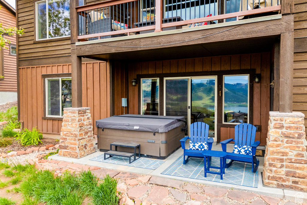 View of patio / terrace with a balcony and a hot tub