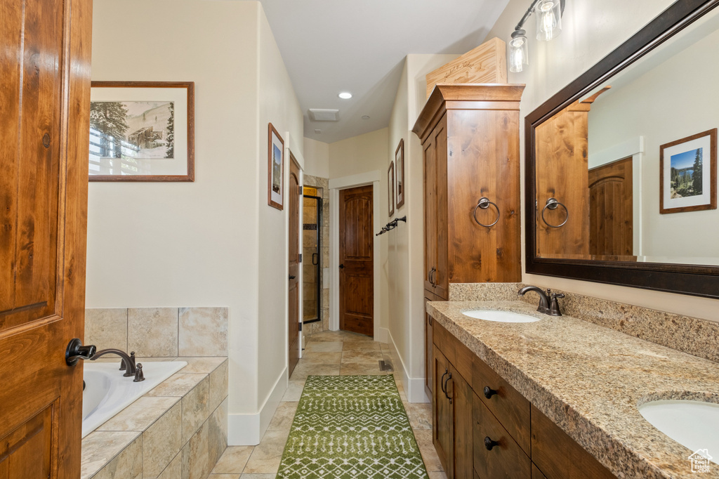 Bathroom with double vanity, a garden tub, baseboards, and recessed lighting