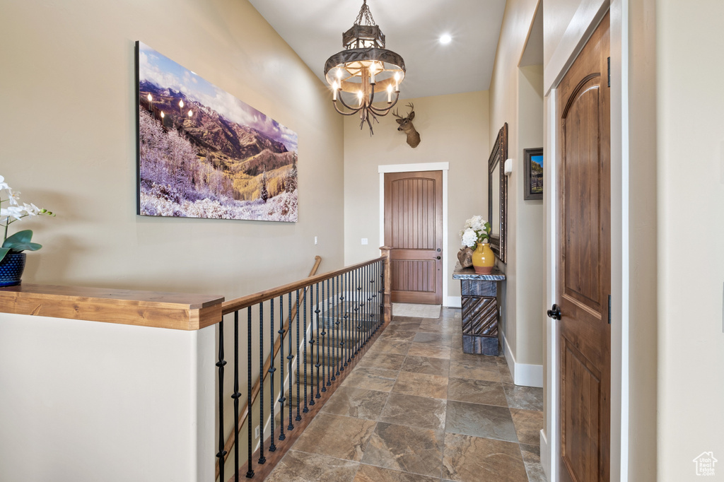 Entrance foyer featuring stone finish floors, a chandelier, baseboards, and recessed lighting