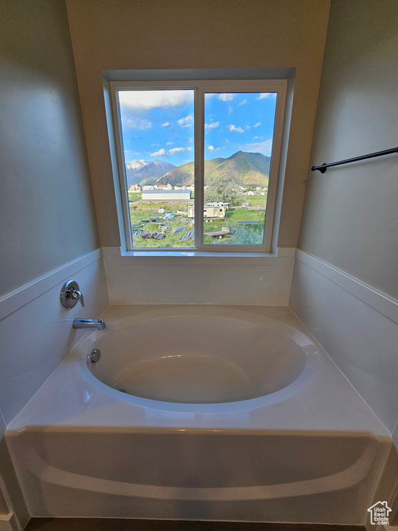 Bathroom featuring a mountain view, plenty of natural light, and a garden tub
