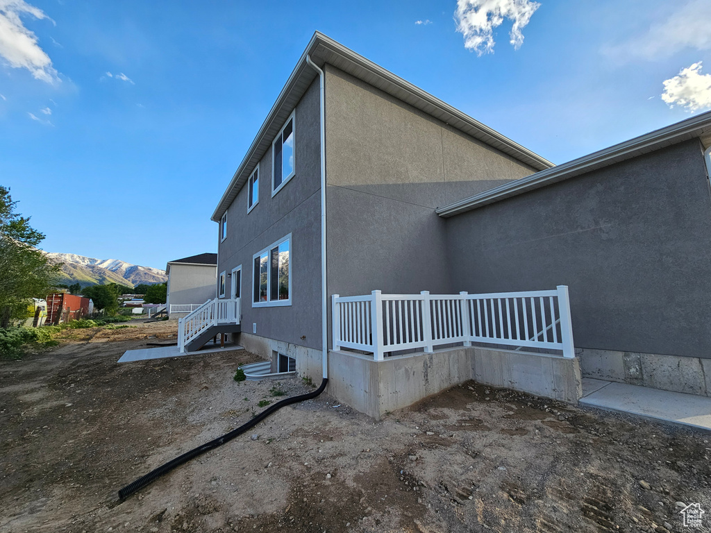 View of side of home with a mountain view and stucco siding